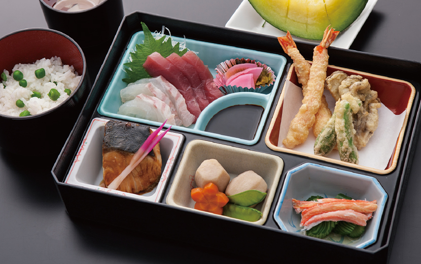 介護施設の栄養バランスに配慮した弁当。刺身、天ぷら、卵焼きなど多品目を盛り込んだ食事